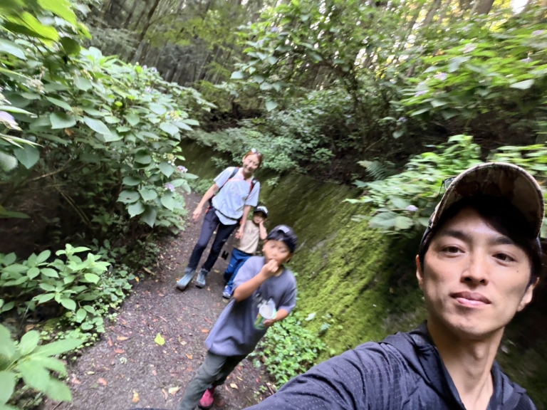 八重山五感の森の苔むした登山道を山頂へ向かって歩く家族