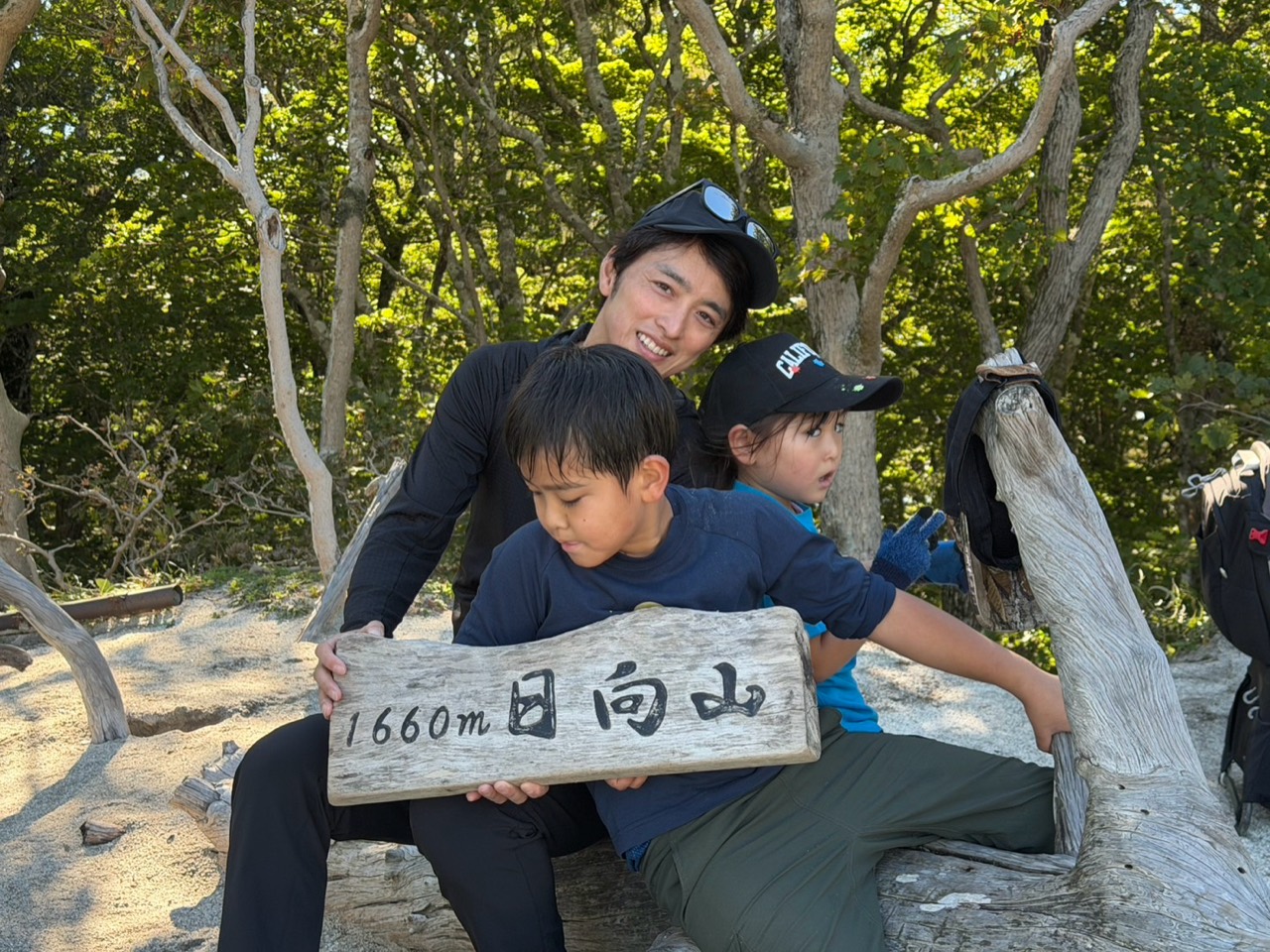 日向山山頂の親子 標高1660メートルの日向山山頂標識を持って記念撮影する親子